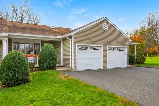a view of a house with a small yard and a garage