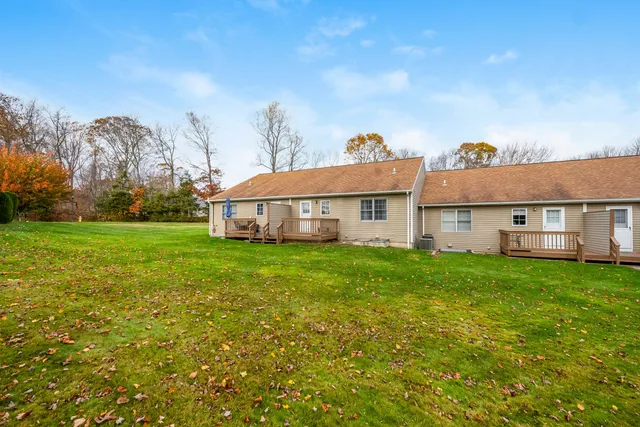a view of a house with a big yard and large trees