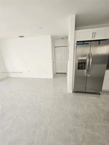 a kitchen with granite countertop white cabinets white stainless steel appliances and a sink