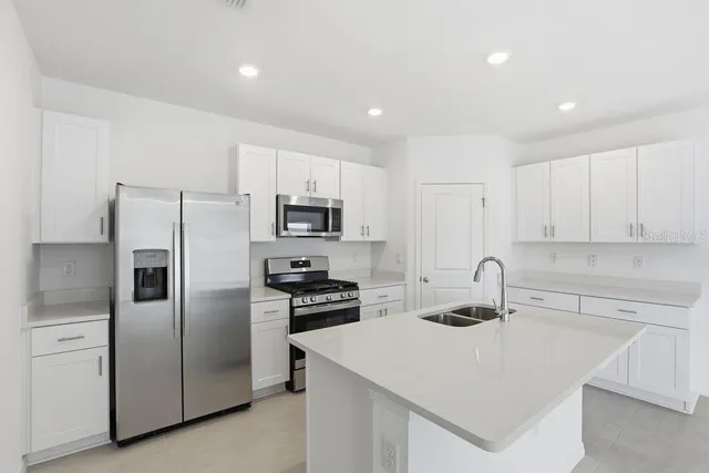 a kitchen with stainless steel appliances a refrigerator sink and stove