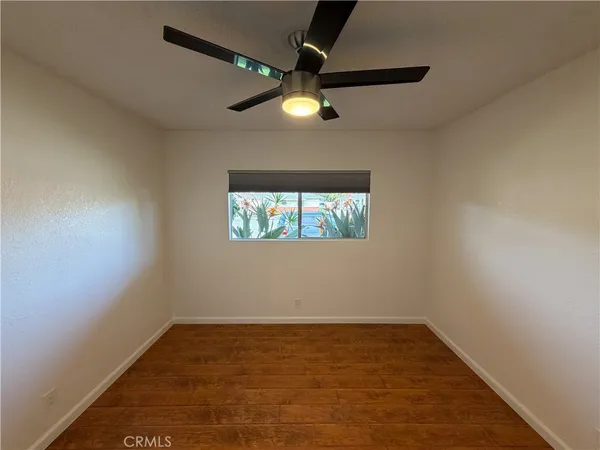 an empty room with a window and a ceiling fan