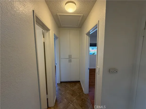 a view of a hallway with wooden shelves
