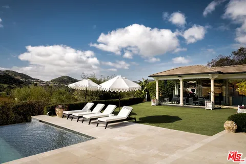 a view of a house with backyard porch and sitting area