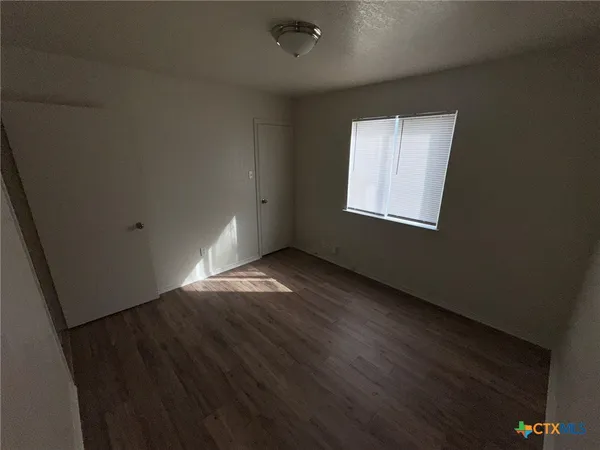 a view of a hallway with wooden floor and chandelier