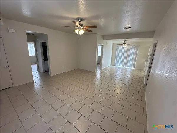 a view of an empty room and a ceiling fan