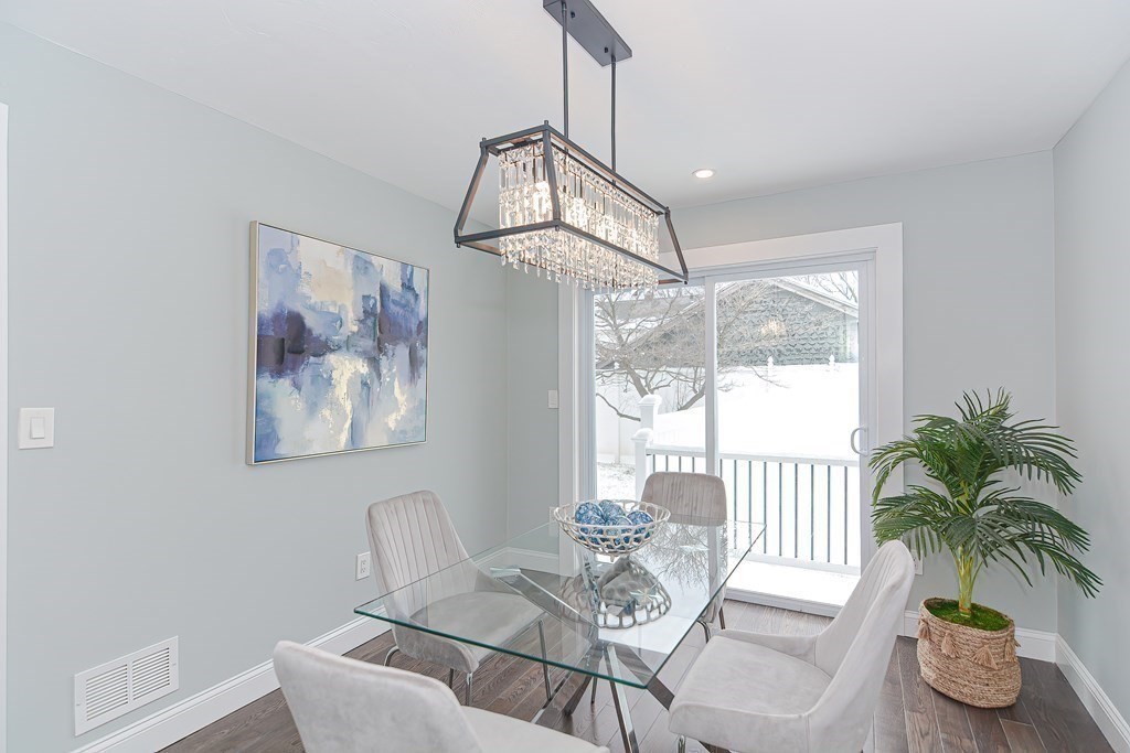 287 Cherry Street, Unit 1 Newton, MA 02465 - Photo 11 of 30 a dining room with furniture a chandelier and wooden floor