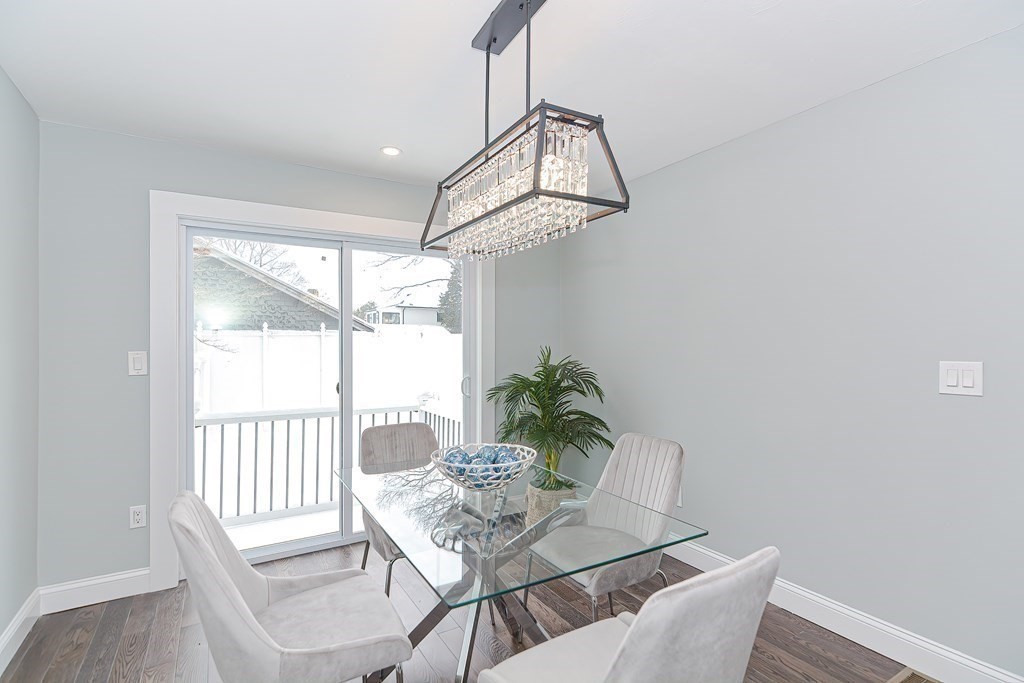 287 Cherry Street, Unit 1 Newton, MA 02465 - Photo 12 of 30 a dining room with furniture a chandelier and wooden floor