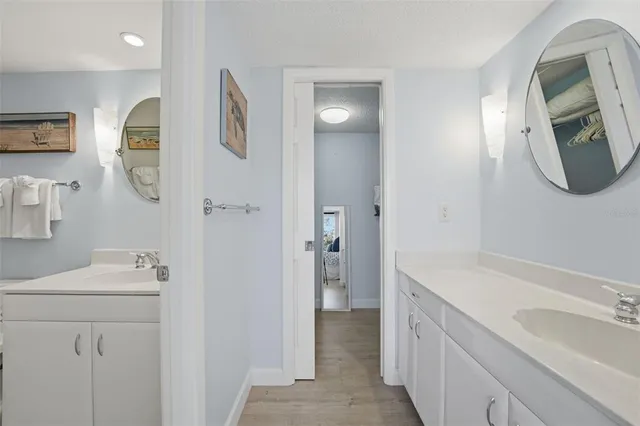 a bathroom with a double vanity sink mirror and bathtub