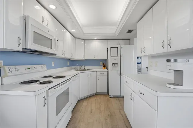 a kitchen with white cabinets and white appliances