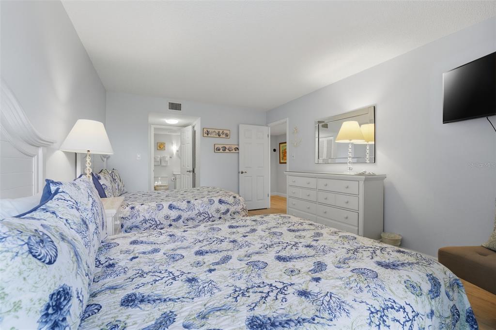 6415 Midnight Pass Road, Unit 310 Sarasota, FL 34242 - Photo 22 of 62 a bedroom with a bed and a flat screen tv