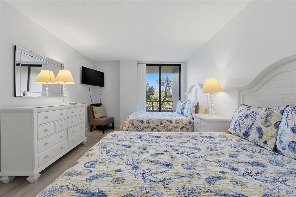 6415 Midnight Pass Road, Unit 310 Sarasota, FL 34242 - Photo 23 of 62 a bedroom with a bed and a dresser in it