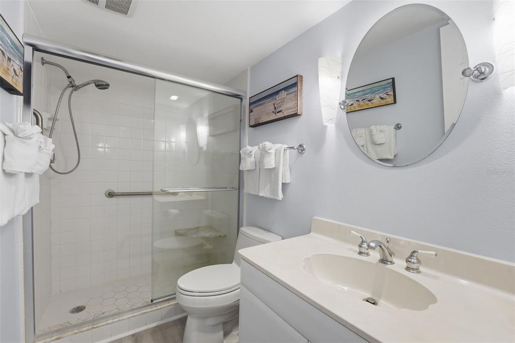 6415 Midnight Pass Road, Unit 310 Sarasota, FL 34242 - Photo 27 of 62 a bathroom with a shower sink vanity and mirror