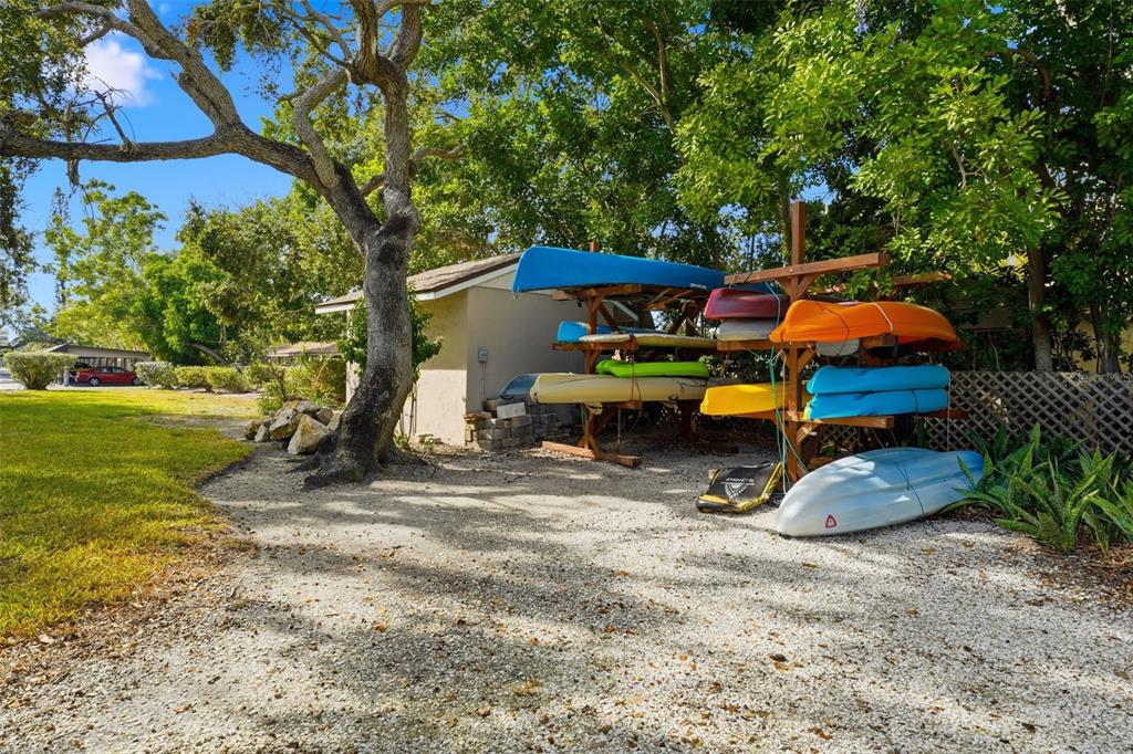 6415 Midnight Pass Road, Unit 310 Sarasota, FL 34242 - Photo 58 of 62 a backyard of a house with barbeque oven table and chairs