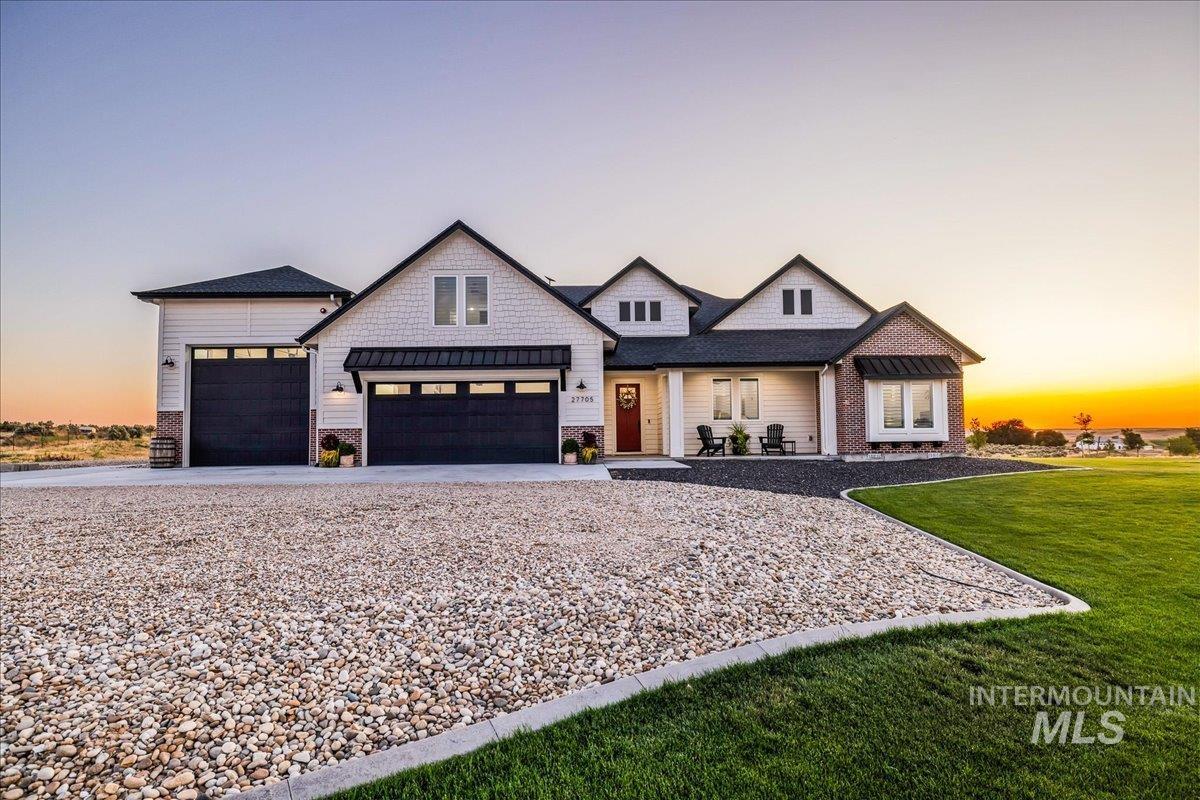 27705 Gray Sage Road Caldwell, ID 83607 - Photo 1 of 1 Modern farmhouse style home featuring an attached garage, a front yard, driveway, a porch, and roof with shingles