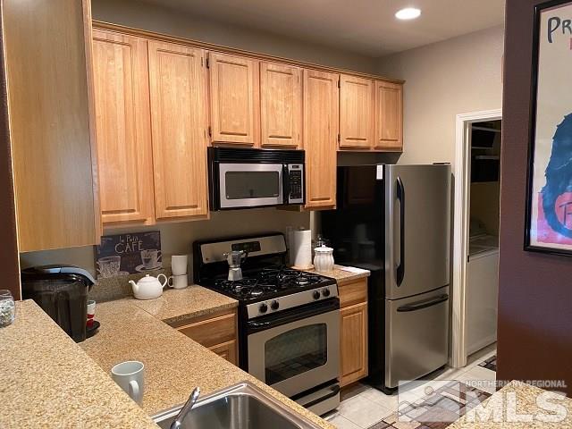 900 S Meadows, Unit 4423 Reno, NV 89521 - Photo 3 of 25 a kitchen with granite countertop a refrigerator stove and microwave