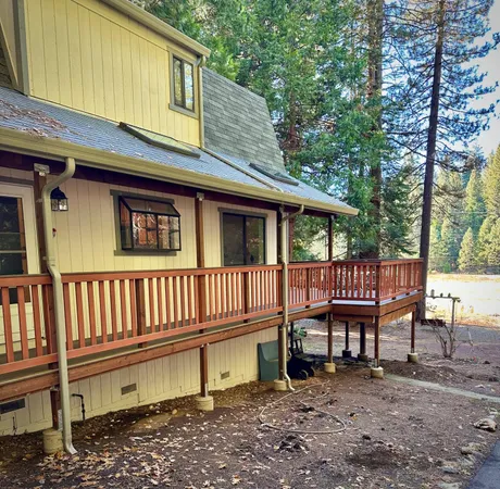 a backyard of a house with deck and outdoor seating