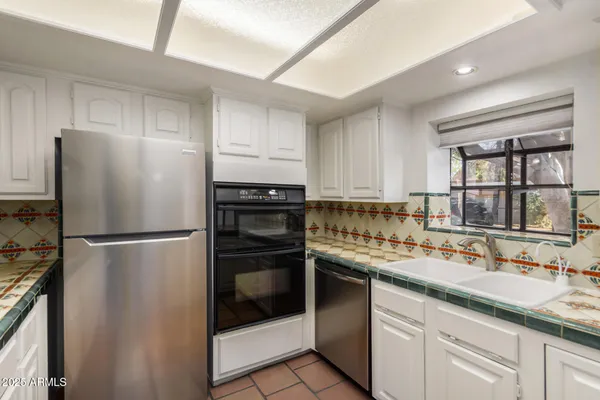 a kitchen with a sink a refrigerator and cabinets