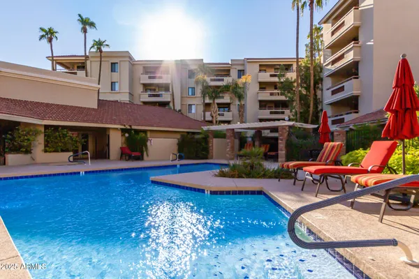 a view of a swimming pool with a lounge chairs in front of building