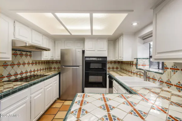 a kitchen with stainless steel appliances kitchen island granite countertop a refrigerator and cabinets