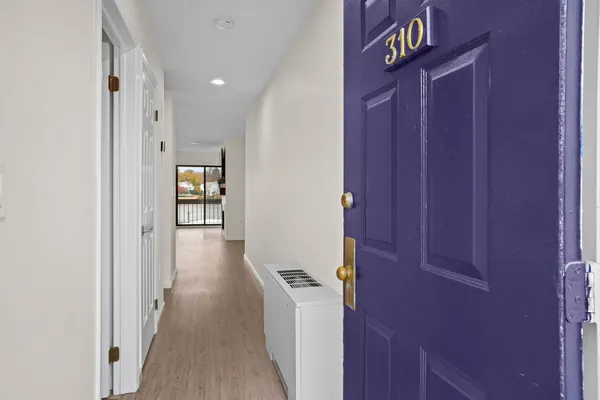 a view of a hallway with wooden floor