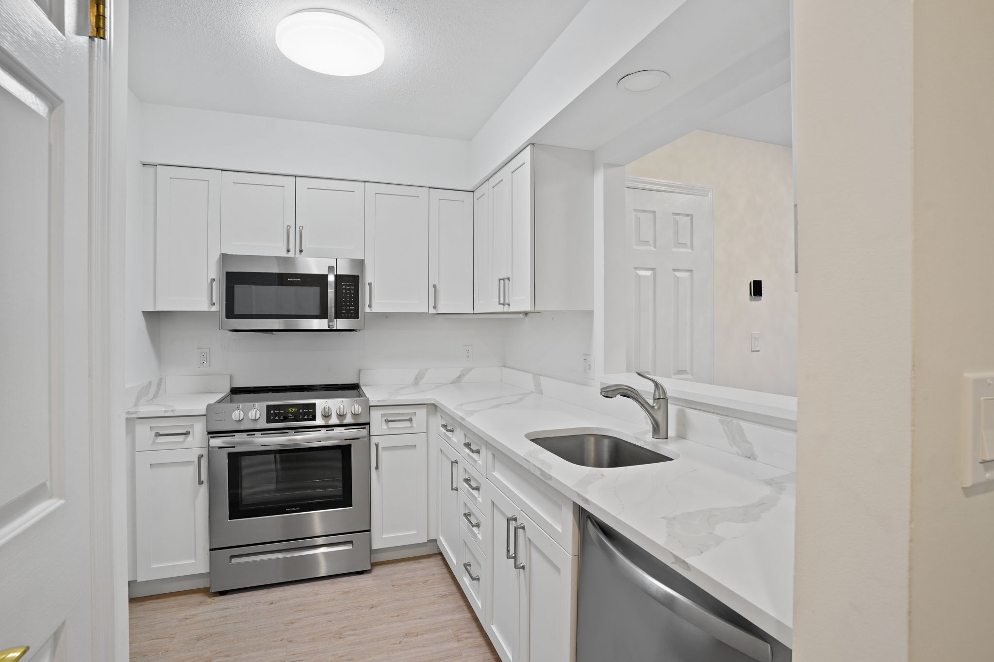 7 River Road, Unit 310 Norwalk, CT 06850 - Photo 4 of 21 a kitchen with white cabinets stainless steel appliances and sink
