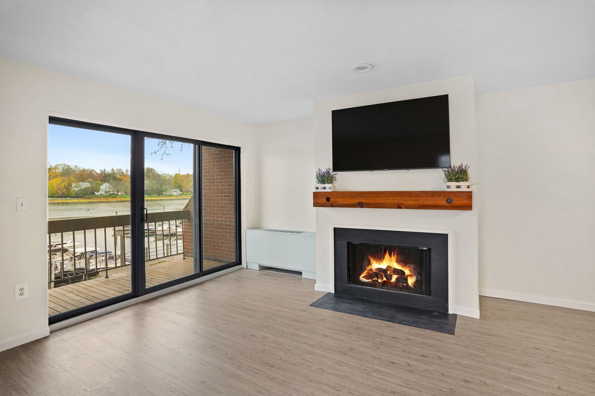 7 River Road, Unit 310 Norwalk, CT 06850 - Photo 10 of 21 a living room with a fireplace a flat screen tv and a fireplace