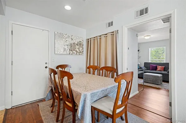 a view of a a dining room with furniture window and wooden floor