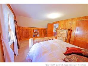 392 Alpine Road Dillon, CO 80435 - Photo 12 of 25 a bedroom with a bed and wooden floor