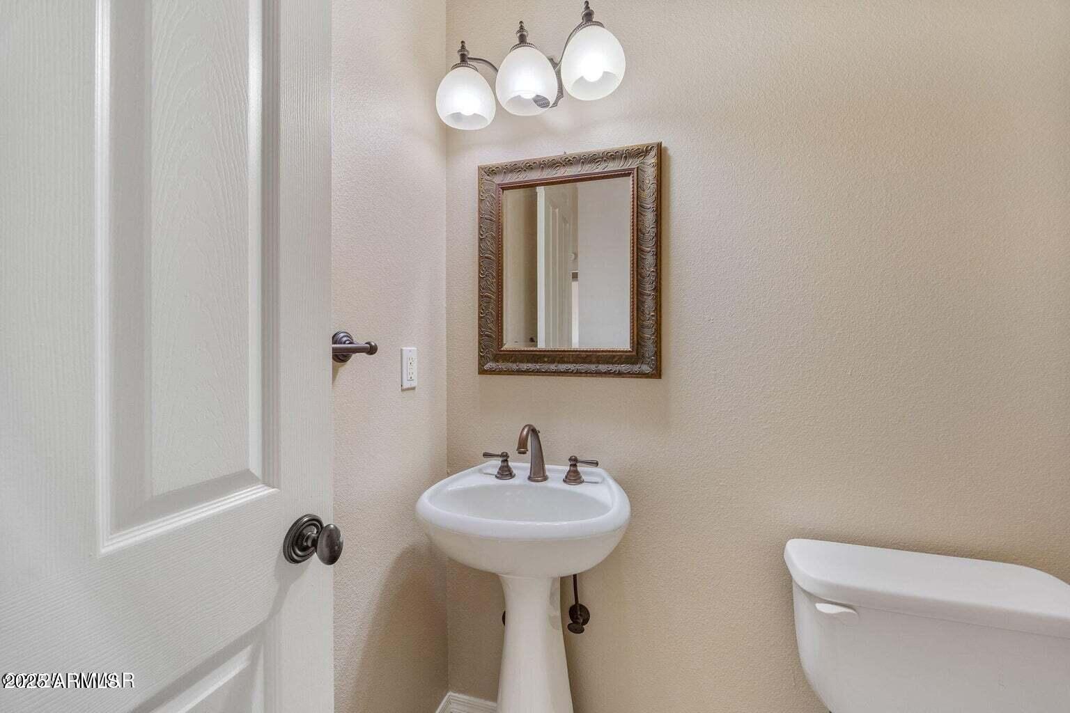1058 East Adams Street Snowflake, AZ 85937 - Photo 12 of 36 a bathroom with a toilet a sink and mirror