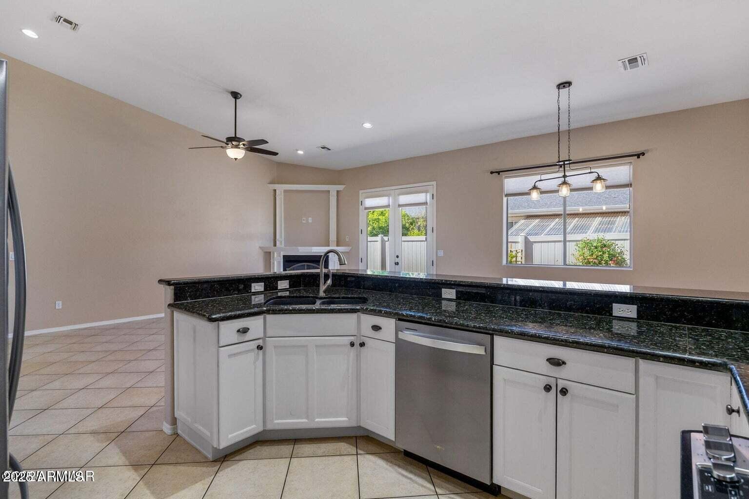 1058 East Adams Street Snowflake, AZ 85937 - Photo 15 of 36 a kitchen with granite countertop a sink and white cabinets