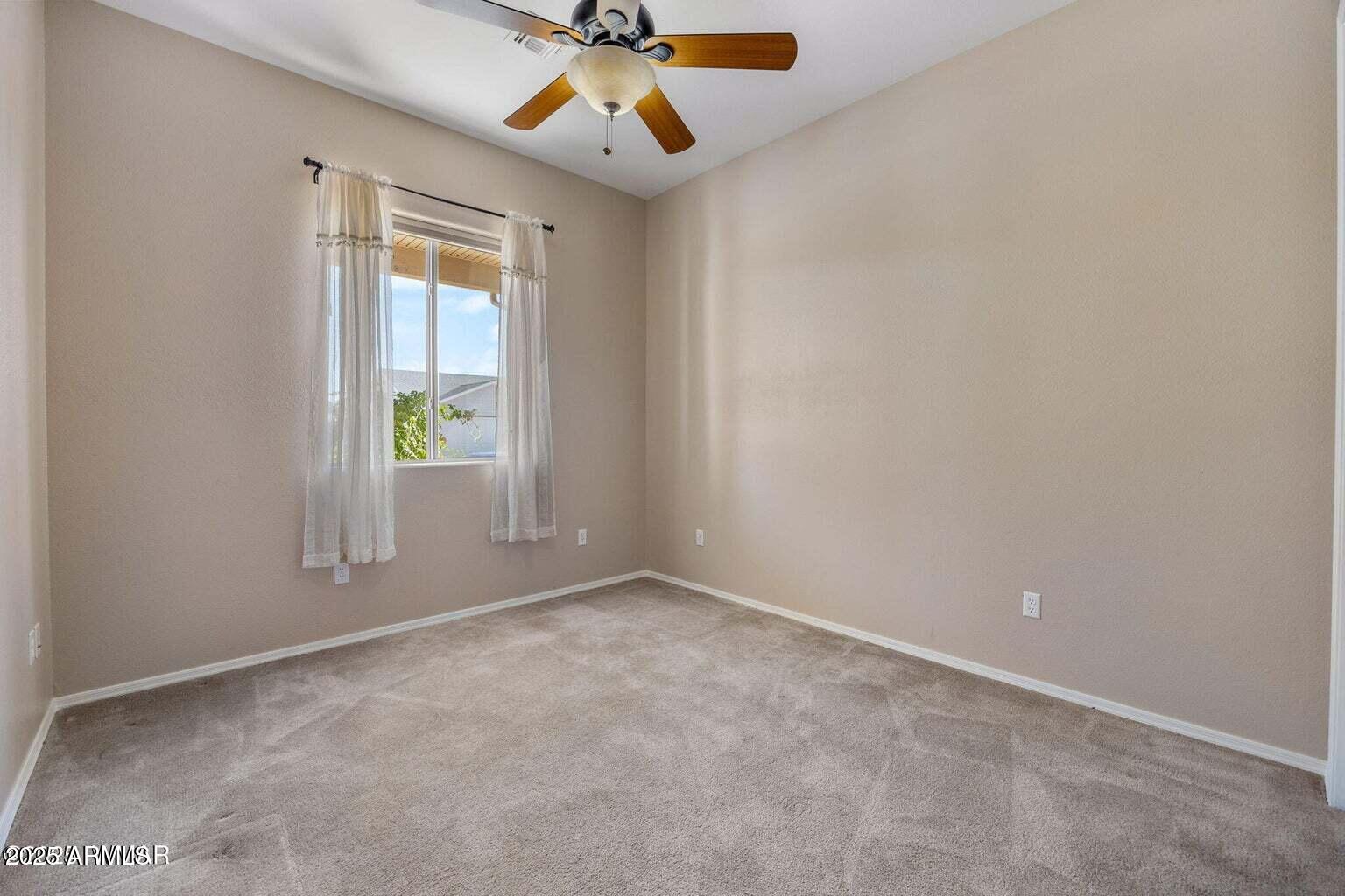 1058 East Adams Street Snowflake, AZ 85937 - Photo 19 of 36 an empty room with a window and a ceiling fan
