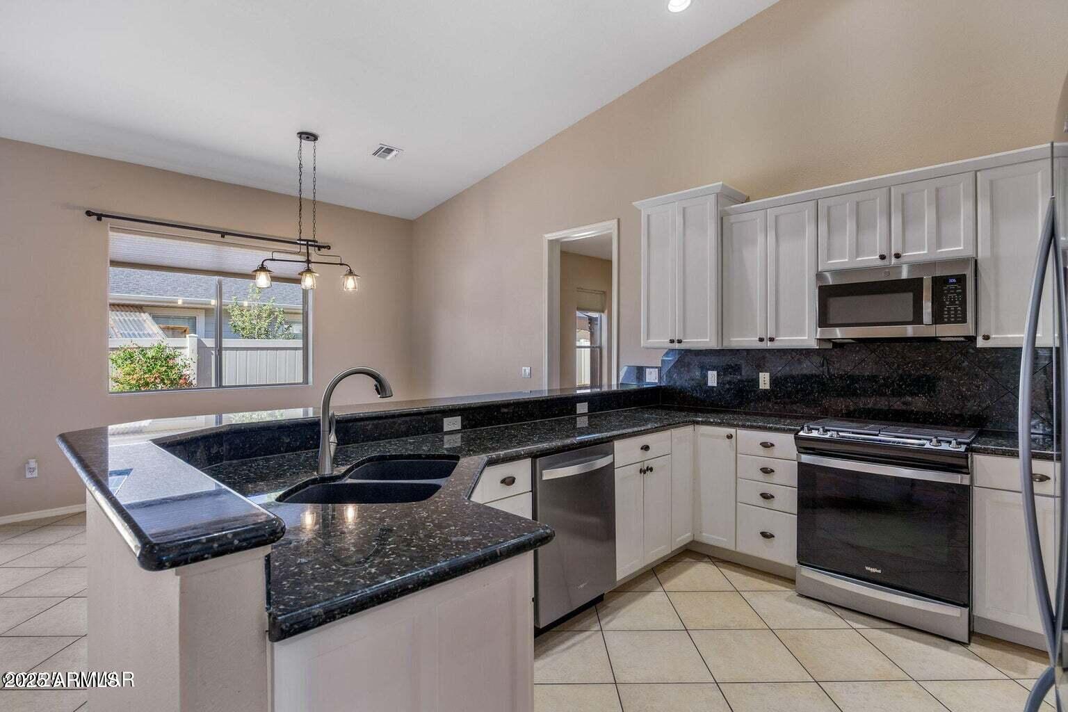 1058 East Adams Street Snowflake, AZ 85937 - Photo 5 of 36 a kitchen with kitchen island granite countertop a sink stove and cabinets