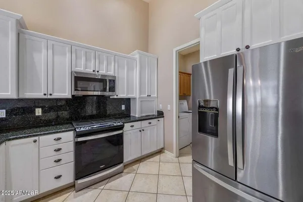 a kitchen with white cabinets stainless steel appliances and a sink