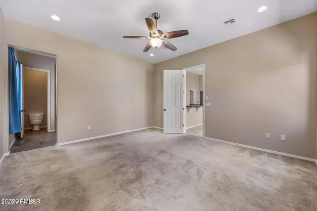 an empty room with closet and a ceiling fan