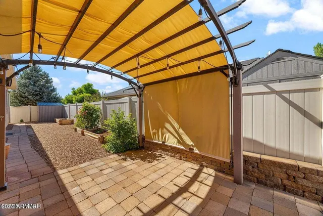 an empty room with windows and chandelier fan