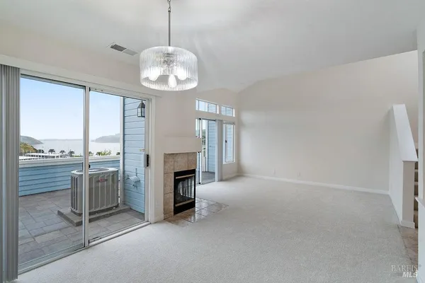 an empty room with fireplace cabinet and windows