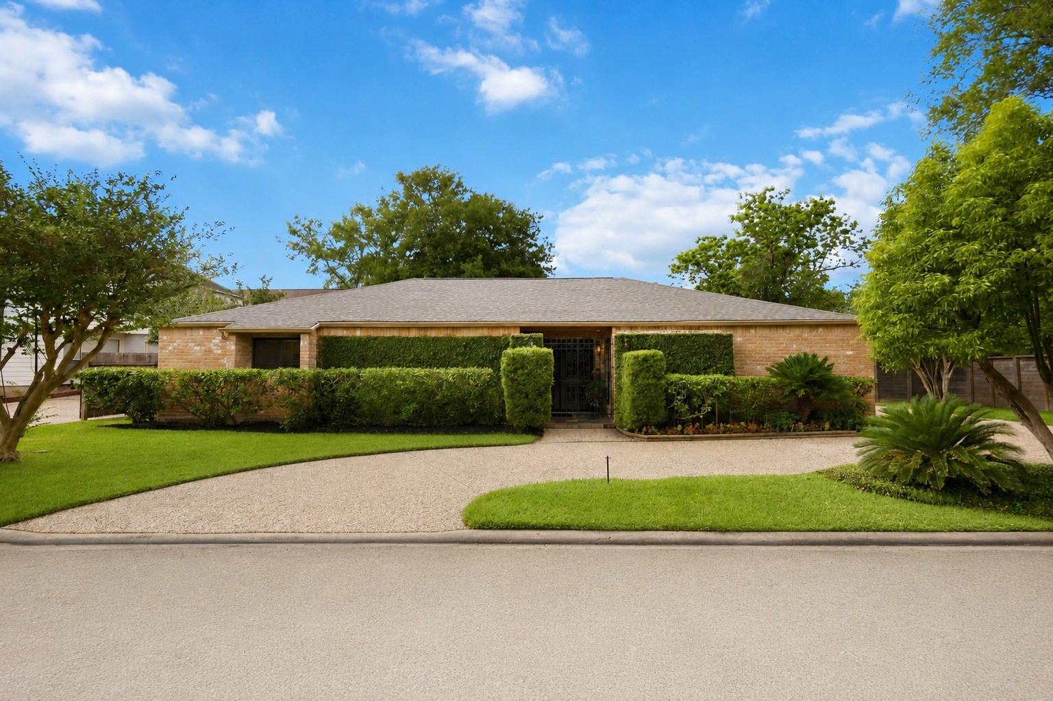619 Rancho Bauer Drive Houston, TX 77079 - Photo 44 of 46 The front of the home is beautifully maintained with lush landscaping and mature greenery, creating a warm and inviting first impression. This unique one-story residence features elegant solid wood double doors, a custom-made iron gate, and exceptional curb appeal full of charm and character.