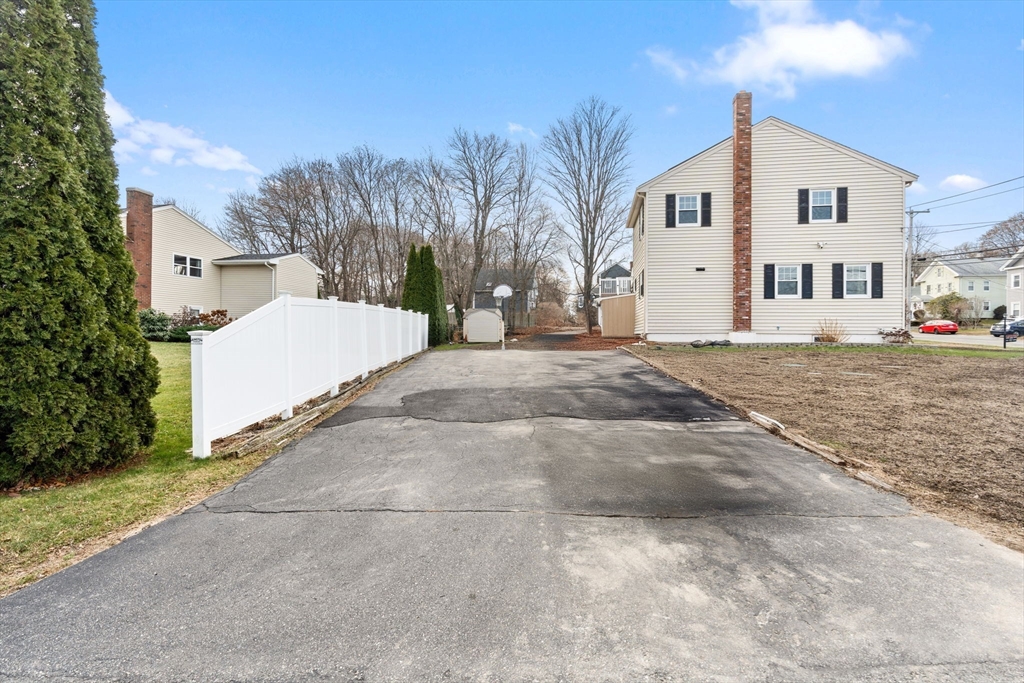 70 West High Street, Unit 2 Avon, MA 02322 - Photo 18 of 22 a view of a white house with a yard and large trees