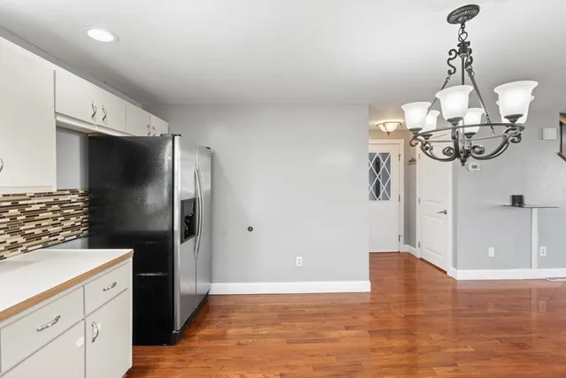 a view of a kitchen with stainless steel appliances granite countertop a refrigerator and a stove top oven