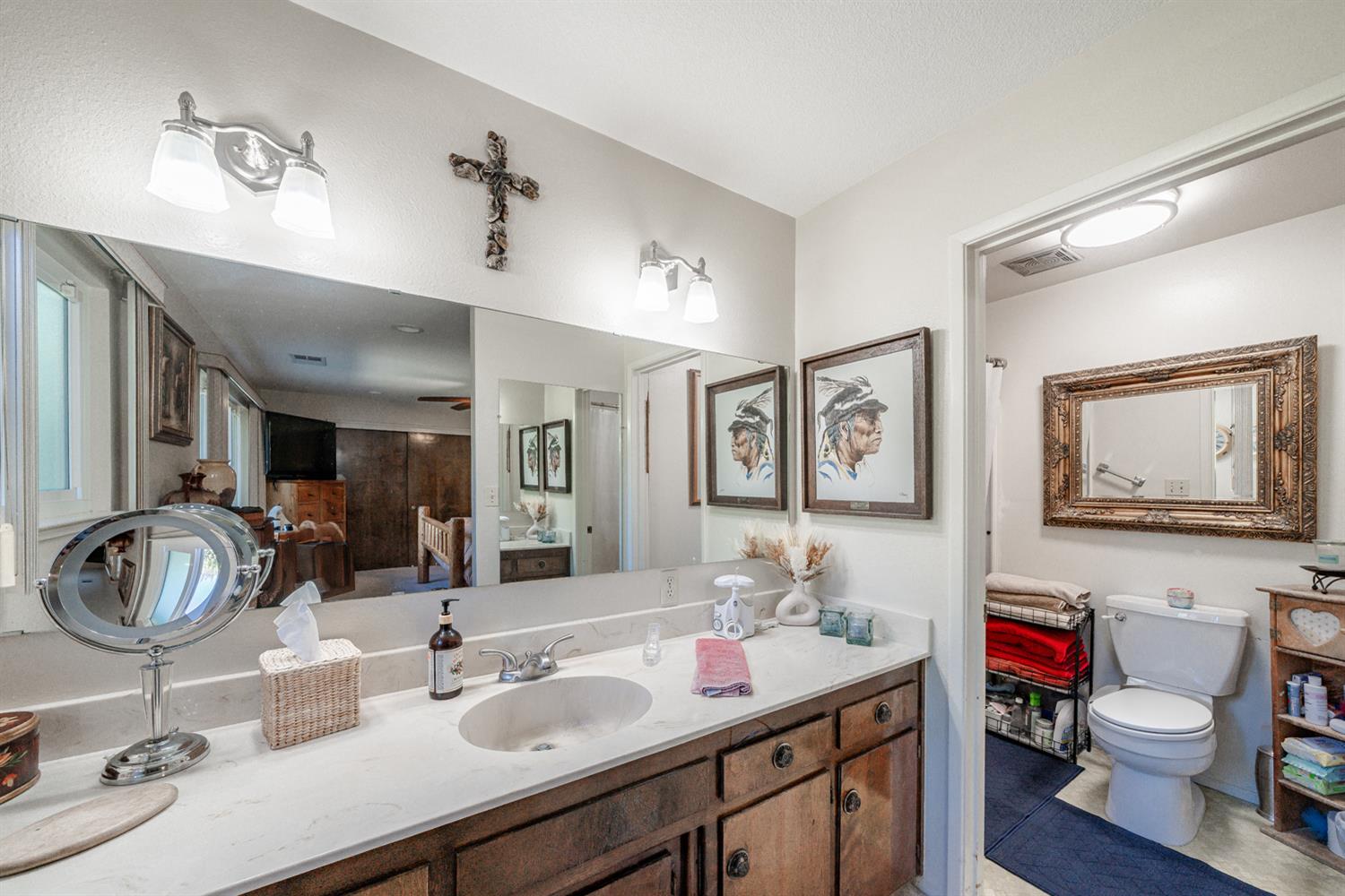 20058 Cardoza Road Los Banos, CA 93635 - Photo 14 of 30 a bathroom with double vanity sinks a mirror and a lamp