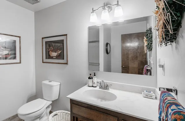 a bathroom with a sink a toilet and a mirror