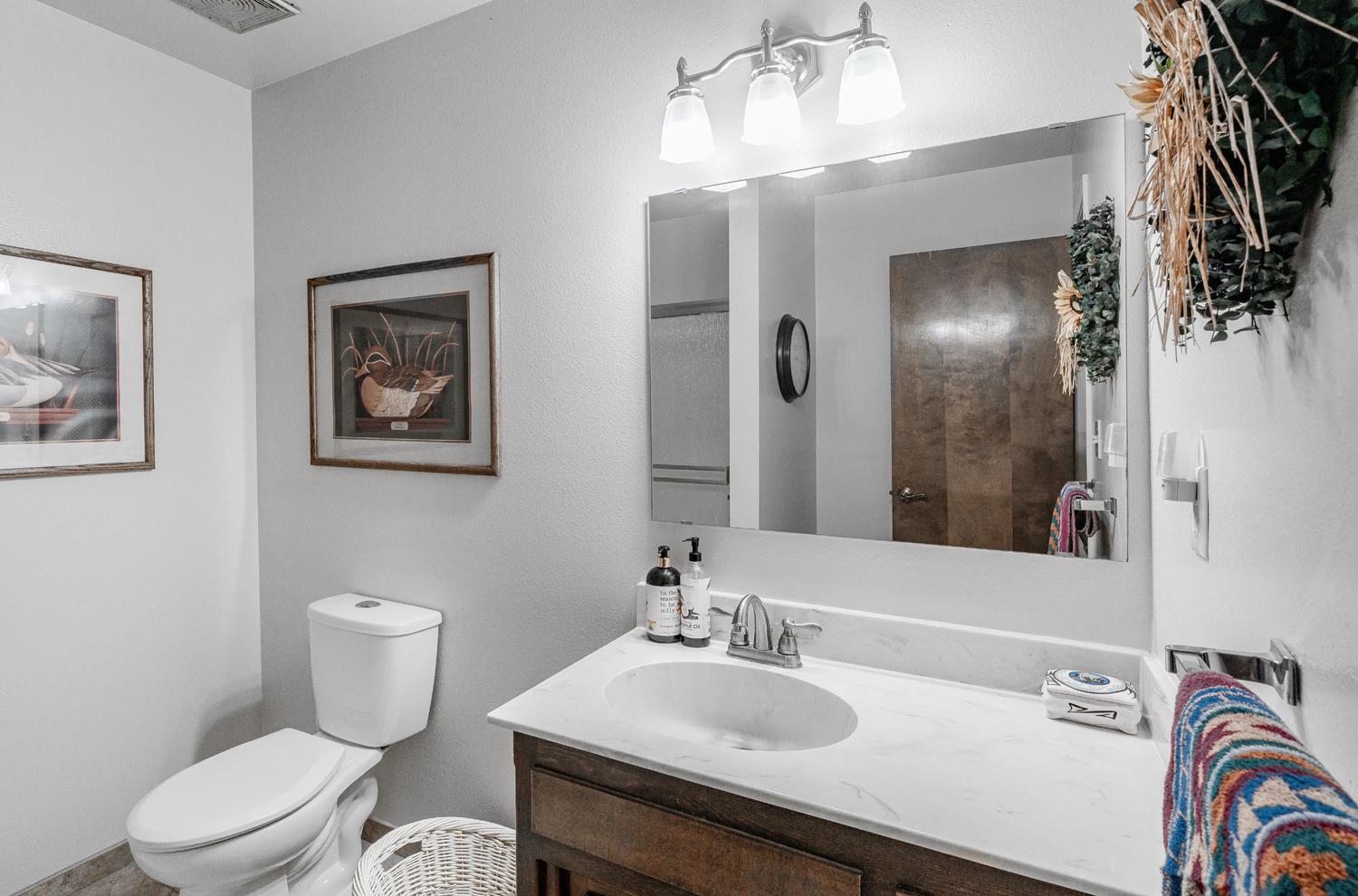 20058 Cardoza Road Los Banos, CA 93635 - Photo 17 of 30 a bathroom with a sink a toilet and a mirror