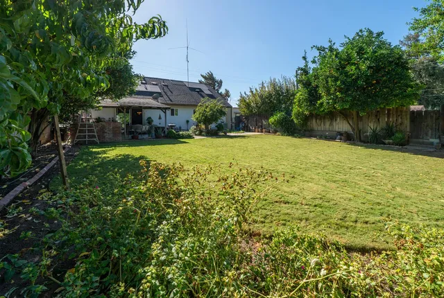 a view of a house with a yard and potted plants