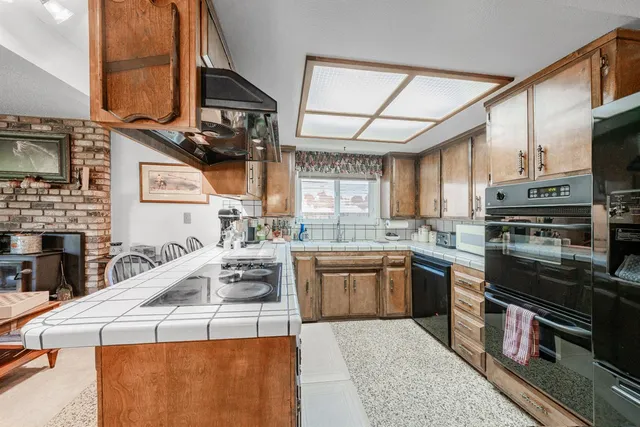 a kitchen with stainless steel appliances granite countertop a sink and a stove