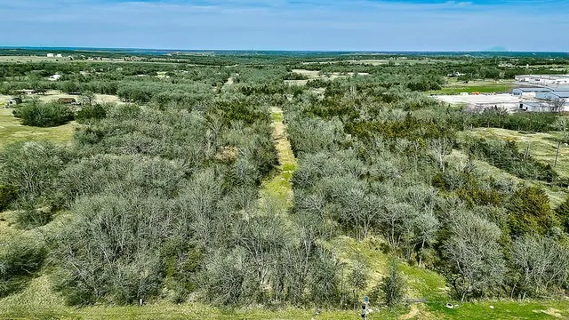 an aerial view of residential houses with outdoor space and trees