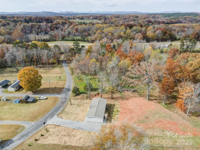 a view of a house with backyard and trees
