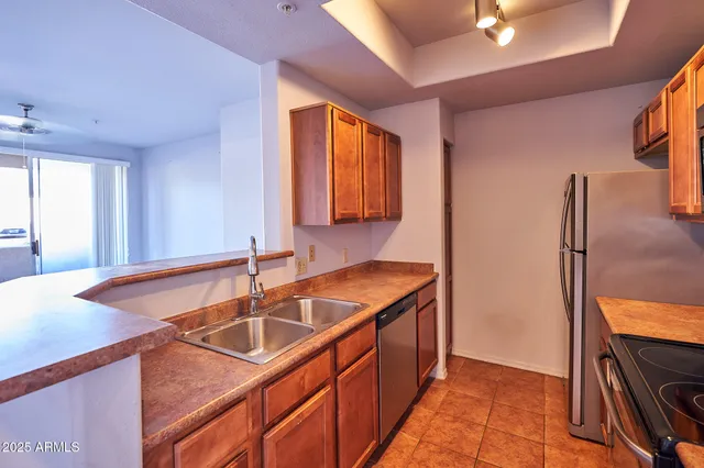 a kitchen with stainless steel appliances granite countertop a sink and a refrigerator