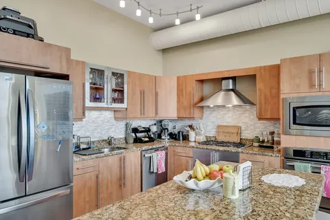 a kitchen with stainless steel appliances granite countertop a stove refrigerator sink and cabinets