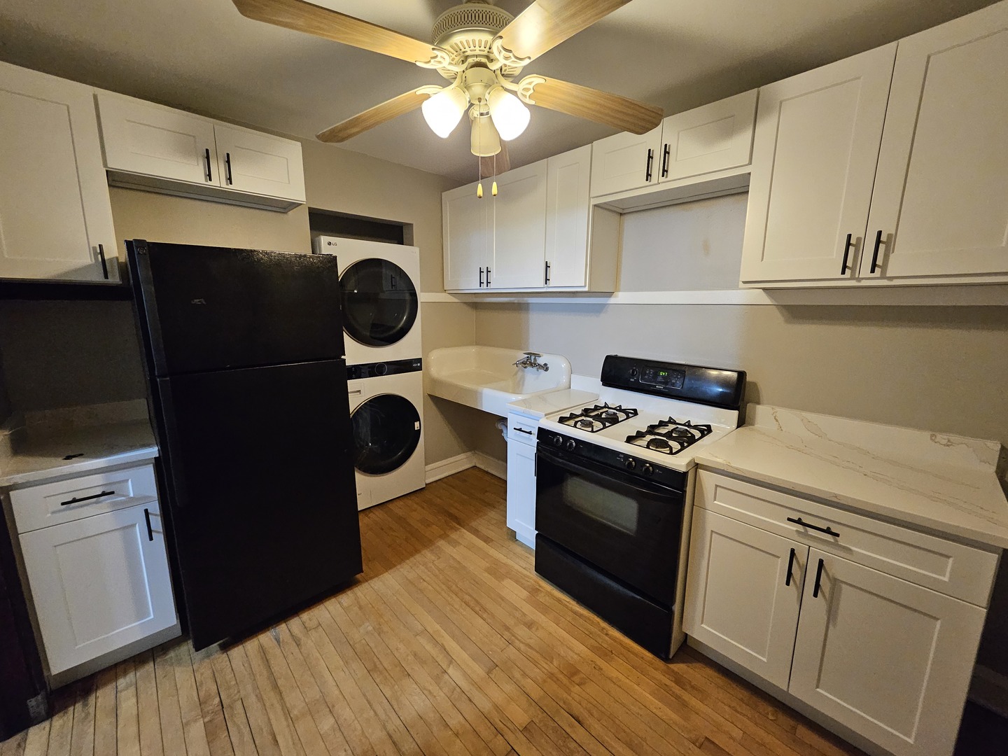 2907 West Lyndale Street, Unit 2R Chicago, IL 60647 - Photo 2 of 11 a kitchen with stainless steel appliances granite countertop a refrigerator a stove and white cabinets with wooden floor