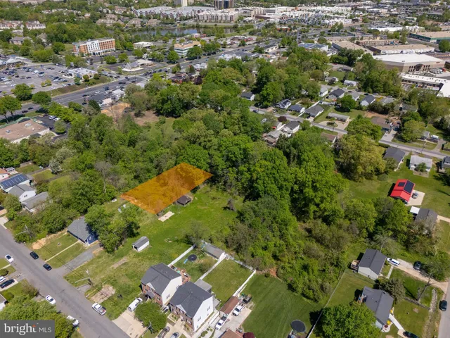 an aerial view of residential houses with outdoor space and trees